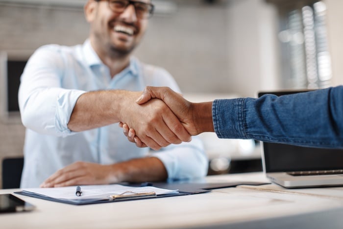 man smiling shaking hands