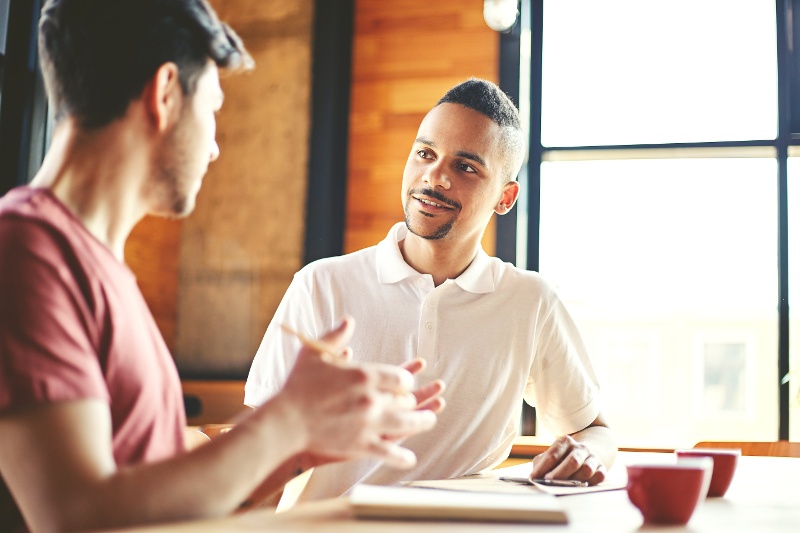 two men chatting over coffee