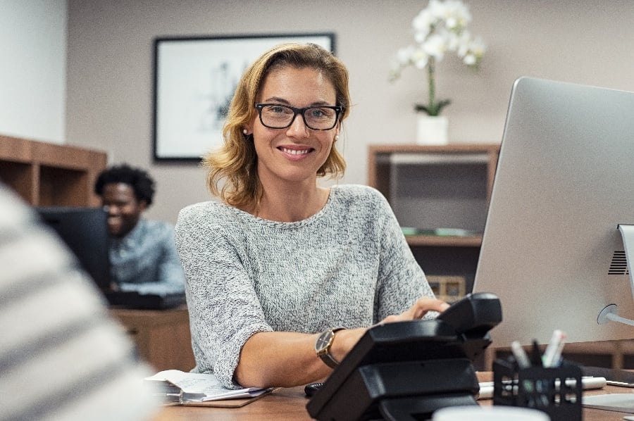 woman smiling at her desk 