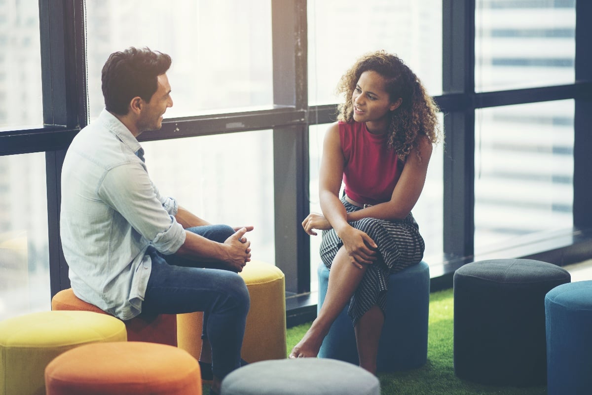 man and woman chatting in office setting