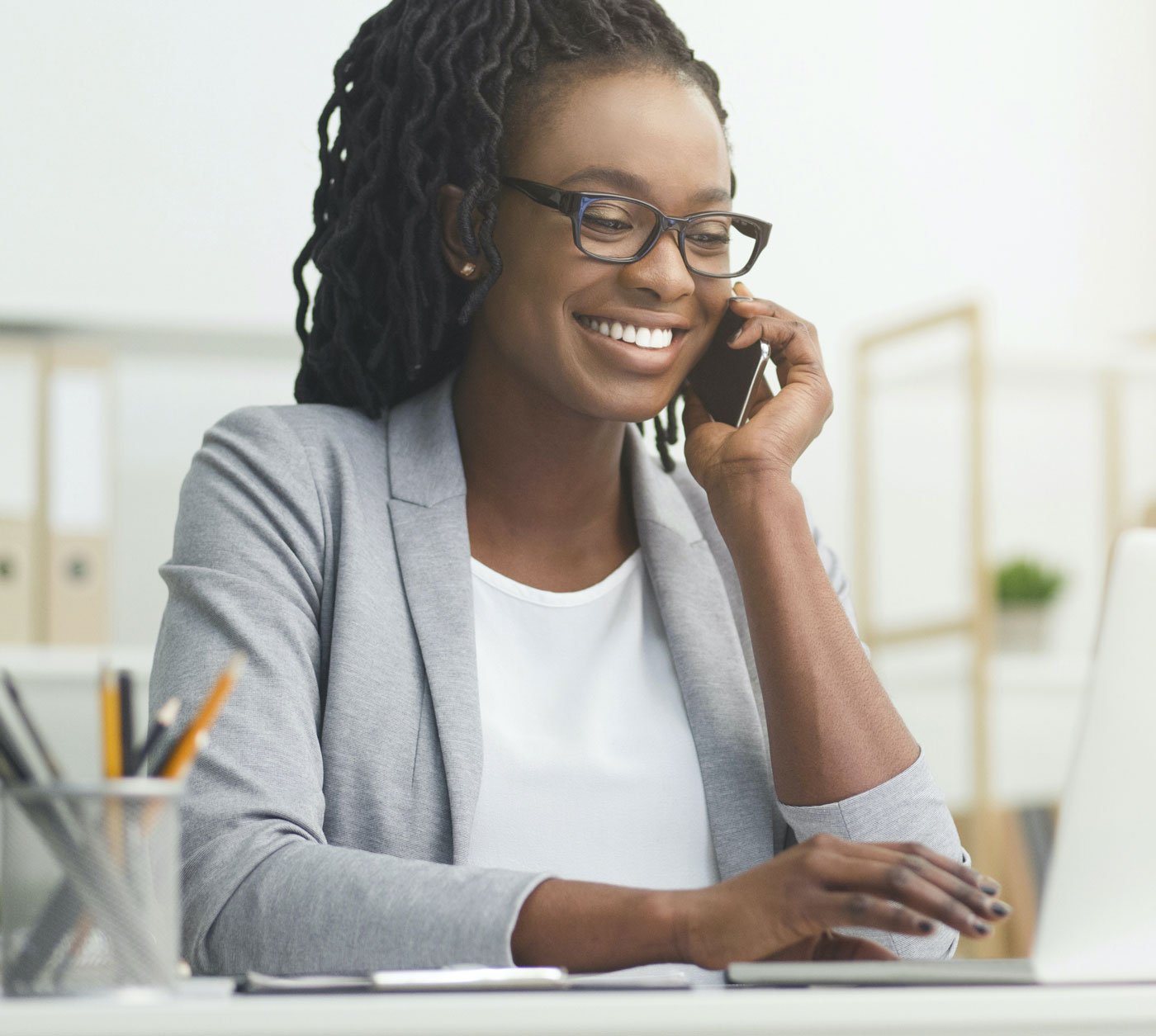 woman on phone and using laptop