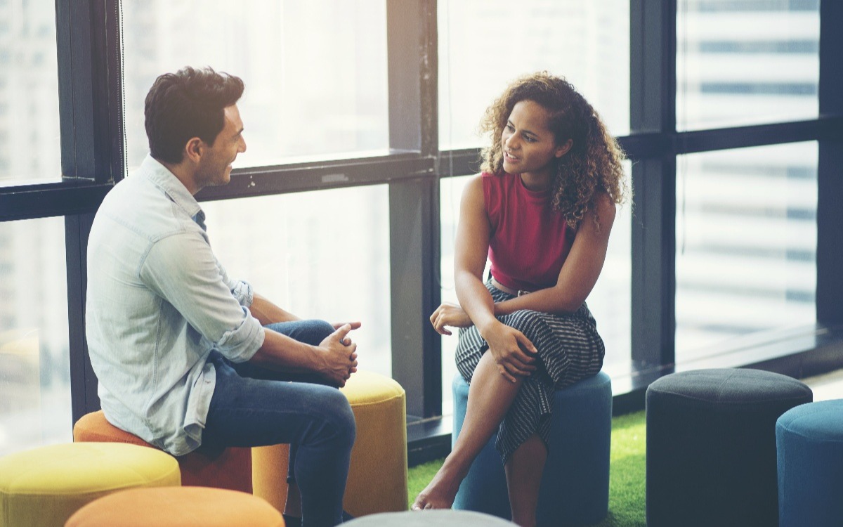 man and woman talking in office